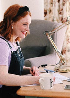 Lydia sitting at her desk smiling