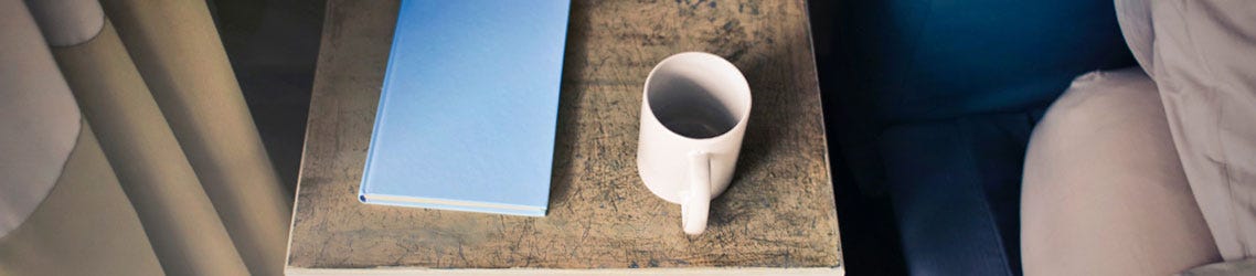 Beside table, with blue journal and coffee mug