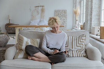 Lady seated writing in a diary